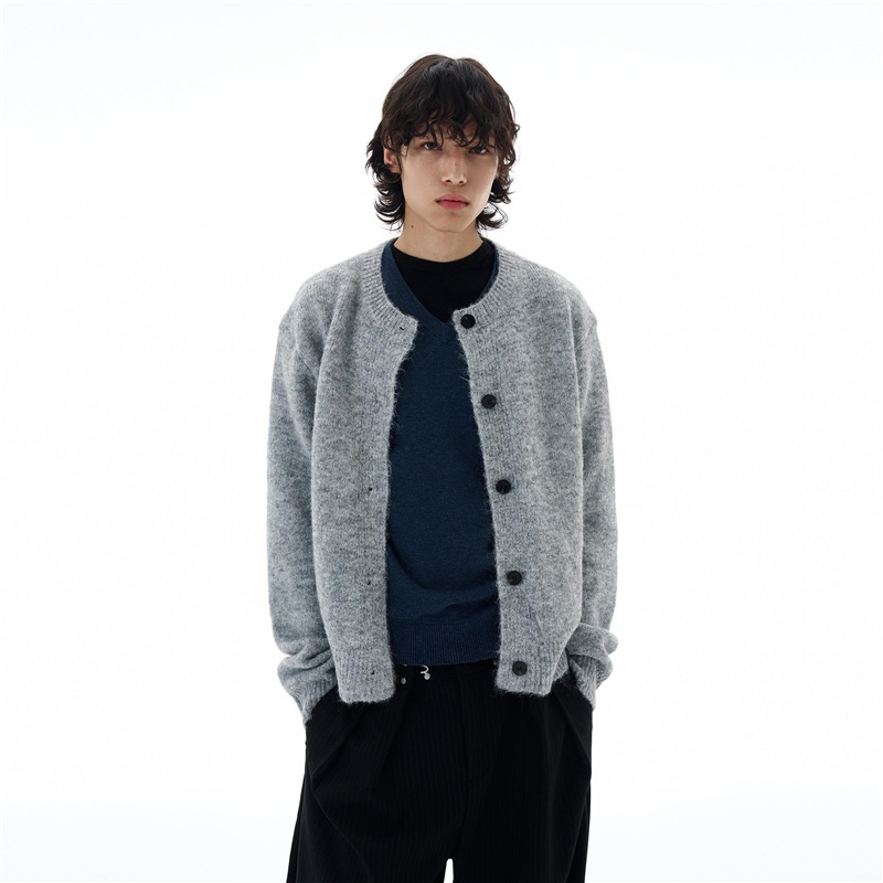 Cardigan tricotat cu nasturi pe față, guler rotund, croială lejeră, mâneci lungi; țesătură din amestec de poliester, 90% poliester.