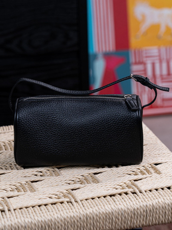 Okrugla cilindrična torbica za olovke od teleće kože, s crossbody naramenicom i zatvaračem; unutarnji pretinci za telefon i dokumente; gradski minimalistički stil