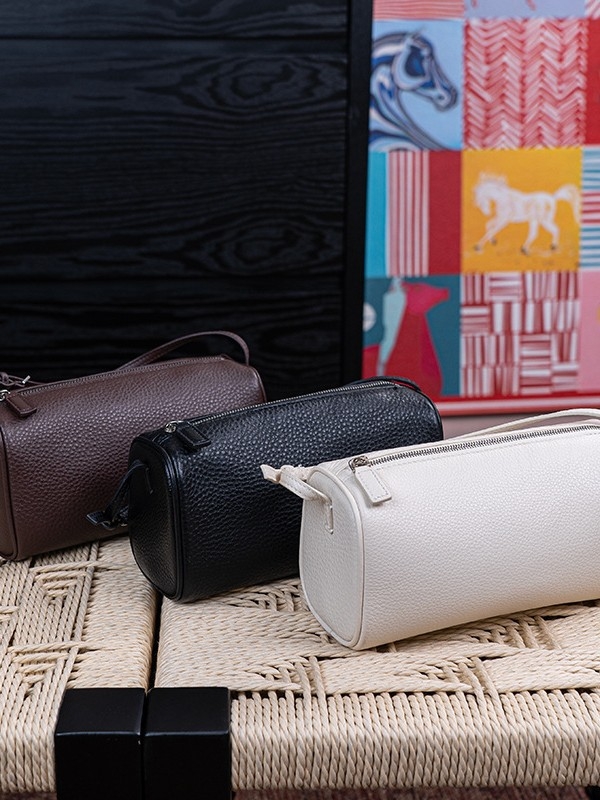 Okrugla cilindrična torbica za olovke od teleće kože, s crossbody naramenicom i zatvaračem; unutarnji pretinci za telefon i dokumente; gradski minimalistički stil