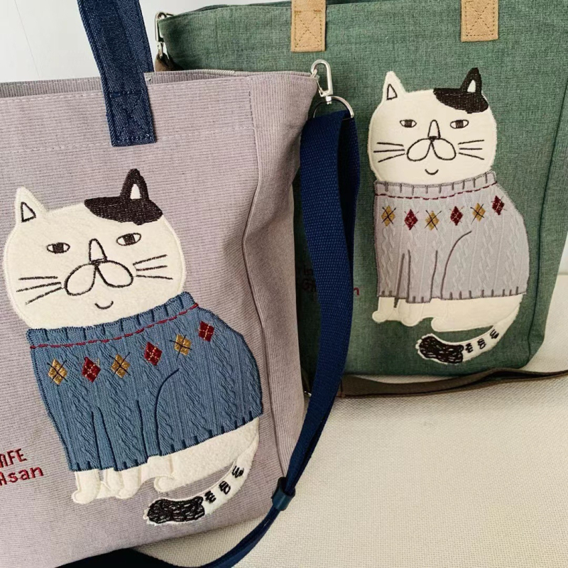 Ukrašena crossbody torba za gradske potrebe — platno, zatvarač, poliester podstava.