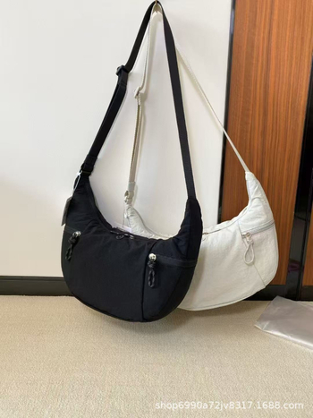 Torba preko ramena u urbanom minimalističkom stilu — platnena, oblik dumpling, zatvaranje zatvaračem, unutarnji džepovi za telefon i dokumente