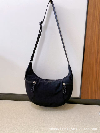 Torba preko ramena u urbanom minimalističkom stilu — platnena, oblik dumpling, zatvaranje zatvaračem, unutarnji džepovi za telefon i dokumente