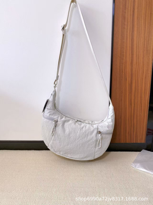 Torba preko ramena u urbanom minimalističkom stilu — platnena, oblik dumpling, zatvaranje zatvaračem, unutarnji džepovi za telefon i dokumente