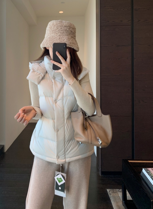 Női kapucnis pehely mellény | 86-90% pehelytartalom | Poliészter anyag | Középmagas hosszúságú 65–80 cm | Egyrészes záródás, álló gallér