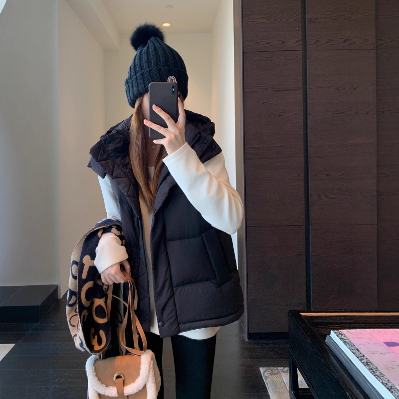 Női kapucnis pehely mellény | 86-90% pehelytartalom | Poliészter anyag | Középmagas hosszúságú 65–80 cm | Egyrészes záródás, álló gallér