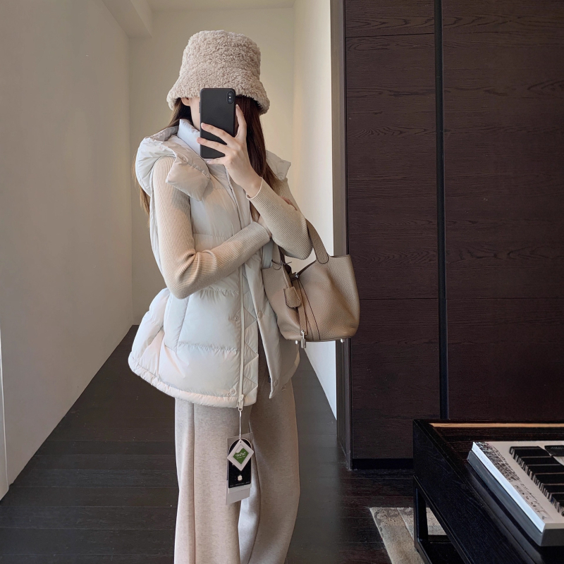 Női kapucnis pehely mellény | 86-90% pehelytartalom | Poliészter anyag | Középmagas hosszúságú 65–80 cm | Egyrészes záródás, álló gallér