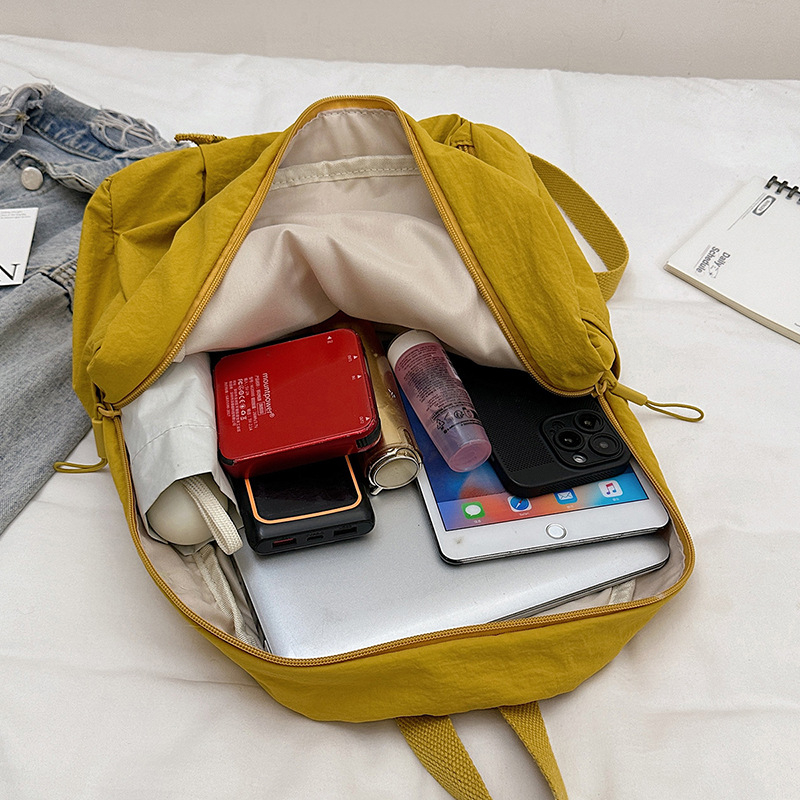 Lagani ženski putni ruksak, pretinac za 12-inčni laptop, oprani materijal, zakrivljene naramenice, uzorak s slovima