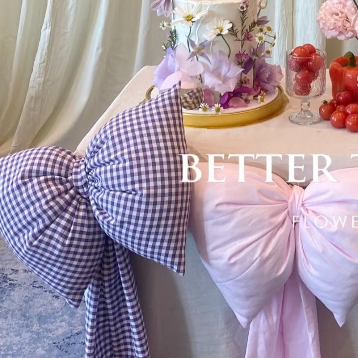 Kockás masnival ellátott textilhátfal rendezvényekhez — selyemvirágokkal, aranyos stílus, helyszín-elrendezési kellék