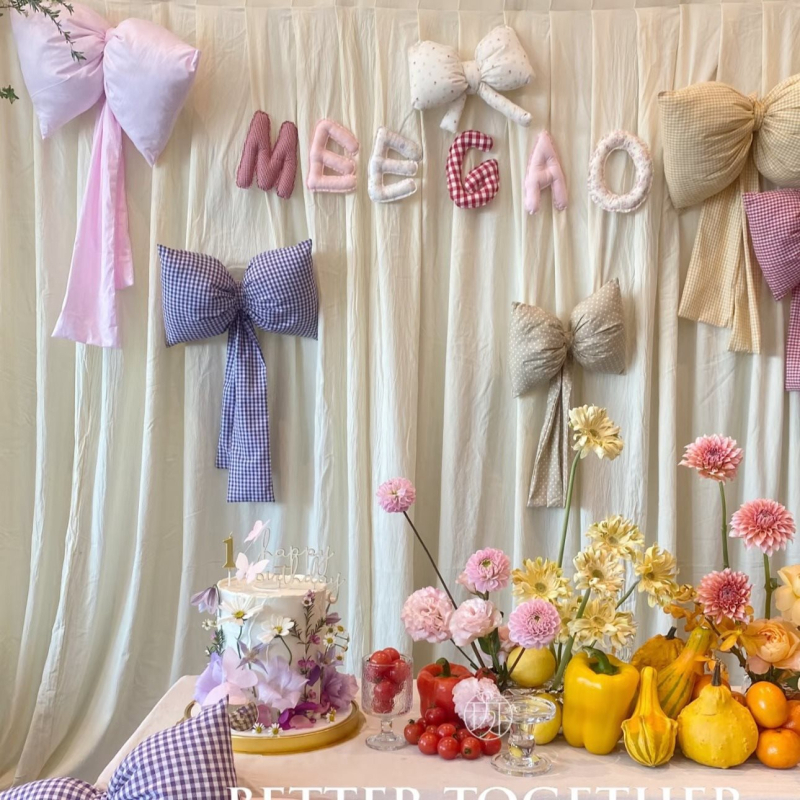 Kockás masnival ellátott textilhátfal rendezvényekhez — selyemvirágokkal, aranyos stílus, helyszín-elrendezési kellék