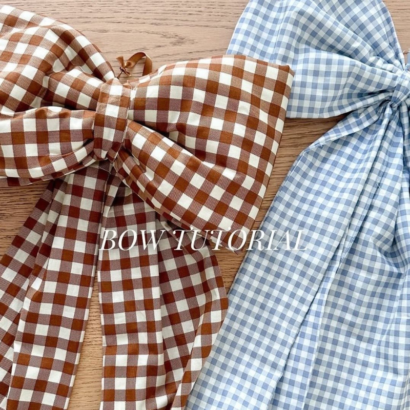 Kockás masnival ellátott textilhátfal rendezvényekhez — selyemvirágokkal, aranyos stílus, helyszín-elrendezési kellék