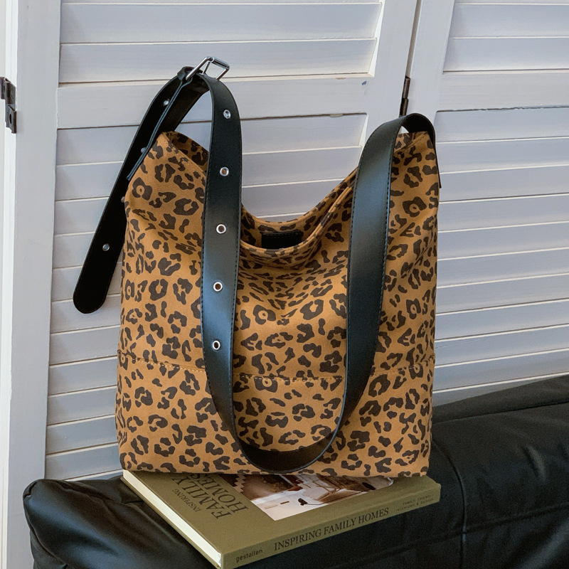 Leopárd minta válltáska PU anyagból, poliészter bélés, vízszintes négyszögletes forma, mágneses zárás, belső zsebek telefonhoz és dokumentumokhoz.