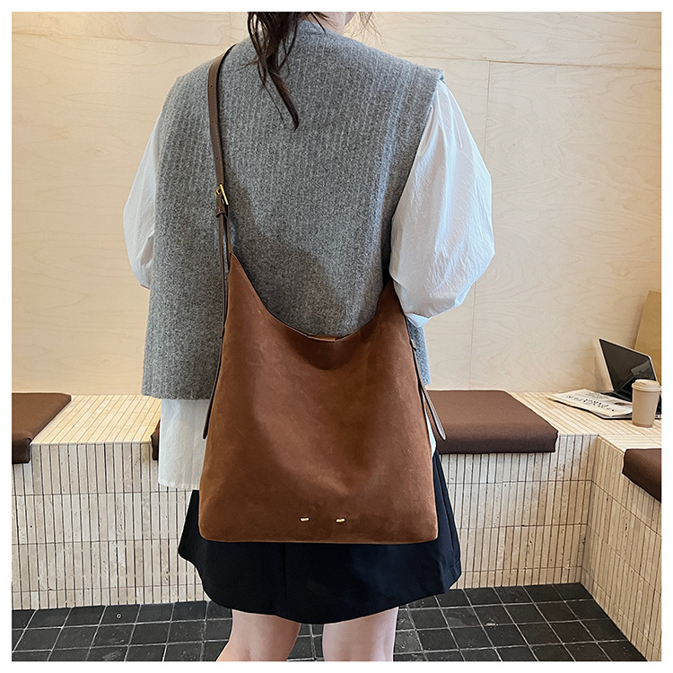 Ženska bucket torba — urbani minimalistički stil, velur od suede materijala, magnetsko zatvaranje, unutarnji džep sa zipom, džep za telefon, džep za dokumente