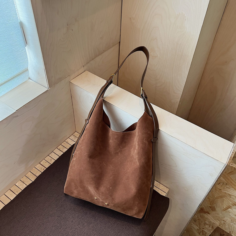 Ženska bucket torba — urbani minimalistički stil, velur od suede materijala, magnetsko zatvaranje, unutarnji džep sa zipom, džep za telefon, džep za dokumente