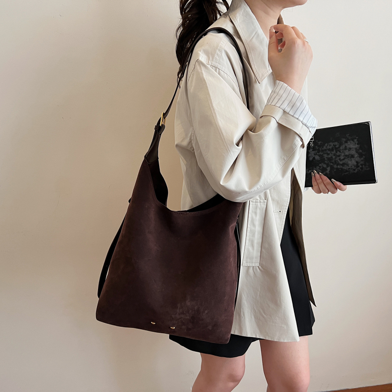 Ženska bucket torba — urbani minimalistički stil, velur od suede materijala, magnetsko zatvaranje, unutarnji džep sa zipom, džep za telefon, džep za dokumente