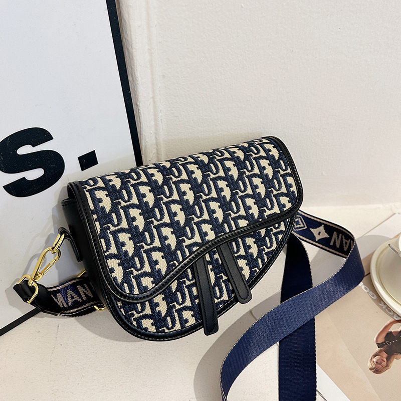 PU bőrű közepes méretű nyerges táska hímzett mintával, kerek forma, cipzár, dupla vállpánt