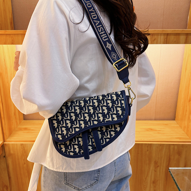 PU bőrű közepes méretű nyerges táska hímzett mintával, kerek forma, cipzár, dupla vállpánt