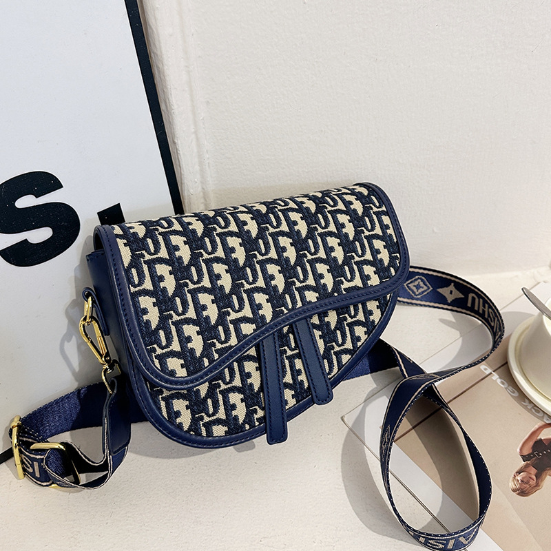 PU bőrű közepes méretű nyerges táska hímzett mintával, kerek forma, cipzár, dupla vállpánt