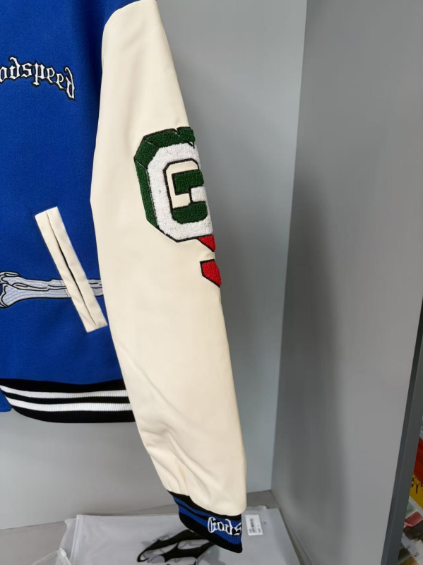 Baseball kabát koponya a hátán és nehéz hímzés, törölköző-hímzés, quiltelt bélés, külső anyag 80% pamut, bélés poliészter, álló gallér, egyszerű gombos zárás, széles szabás, hip-hop streetwear