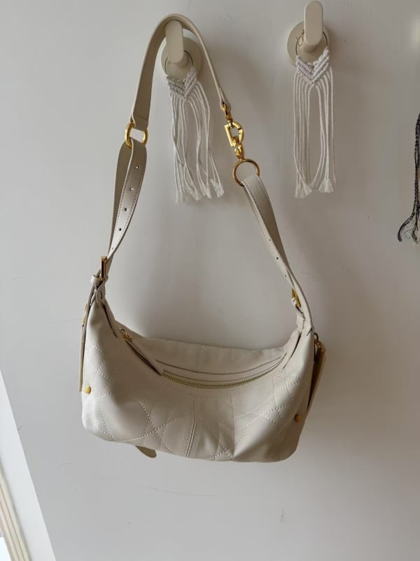 Чанта за рамо от естествена кожа с форма на кнедла, ципово закопчаване и вътрешни джобове, единична презрамка