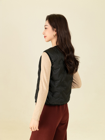 Ženska puffer vest s struknim prilagodom – punilo: bijelo kačje perje; udio perja 80–85%; materijal: poliester; V-izrez