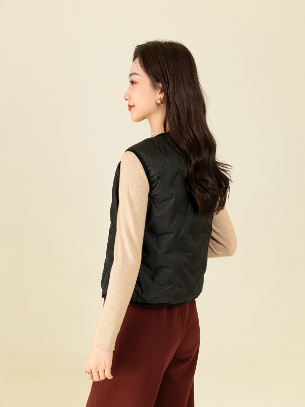 Ženska puffer vest s struknim prilagodom – punilo: bijelo kačje perje; udio perja 80–85%; materijal: poliester; V-izrez