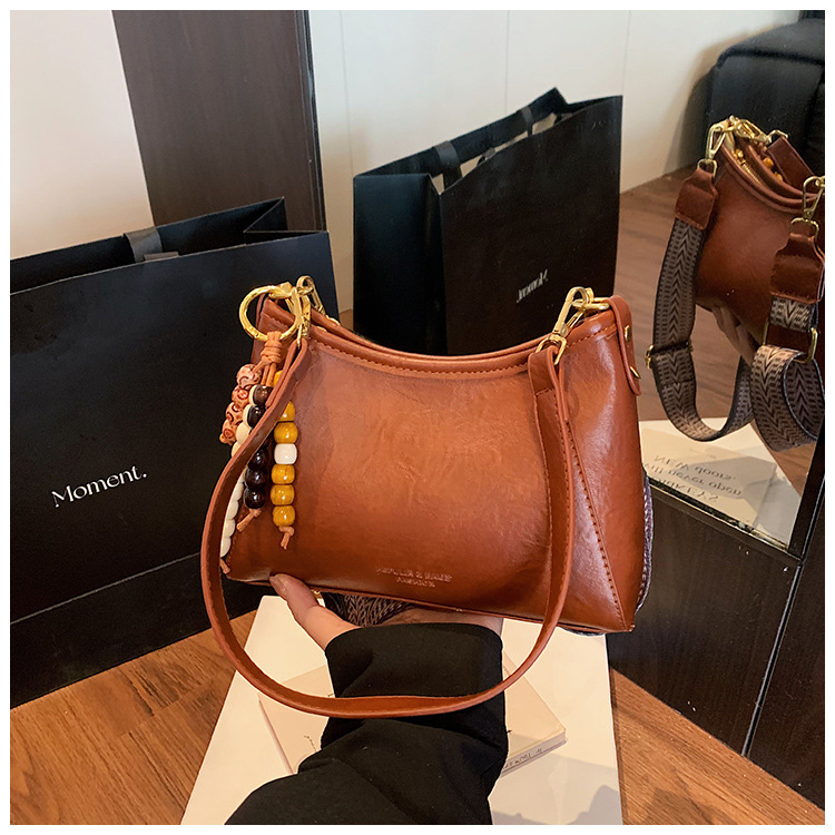 Crossbody torba od PU materijala; zatvaranje rajsferšikom; podstava od poliestera; kvadratnog oblika; džepovi za telefon i dokumente