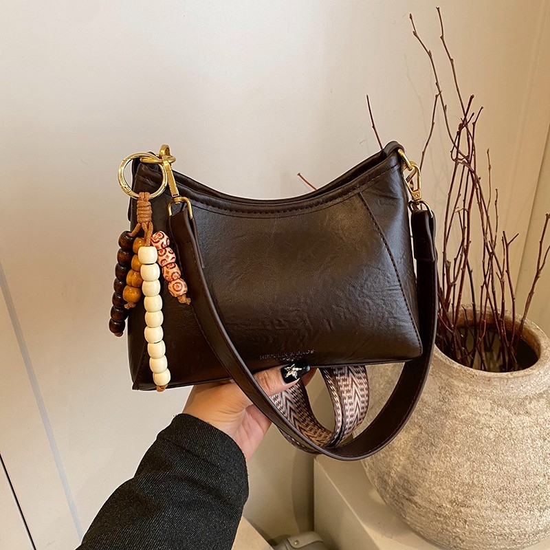 Crossbody torba od PU materijala; zatvaranje rajsferšikom; podstava od poliestera; kvadratnog oblika; džepovi za telefon i dokumente