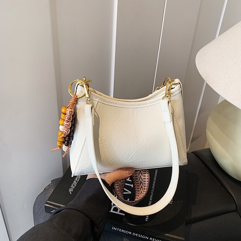 Crossbody torba od PU materijala; zatvaranje rajsferšikom; podstava od poliestera; kvadratnog oblika; džepovi za telefon i dokumente