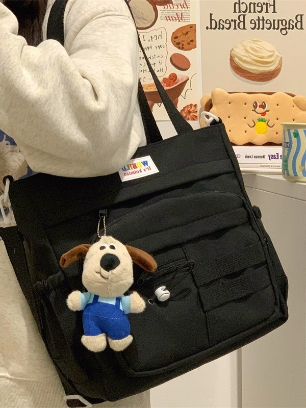 Platnena tote torba s ulicnim stilom, vertikalno kvadratni oblik, zatvaranje na zip, podstava od poliestera, unutarnja džep na zip i džep za telefon, mekana konstrukcija, dvostruke naramenice, pogodna za slobodno vrijeme putovanja.