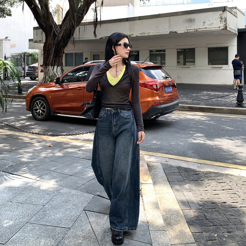 Τζιν με ευρύ παντελόνι, ψηλή μέση από ντένιμ με 70–80% βαμβάκι και έως 30% ινών από αναγεννημένη κυτταλόζη, μήκος μέχρι το δάπεδο, Φθινόπωρο 2025