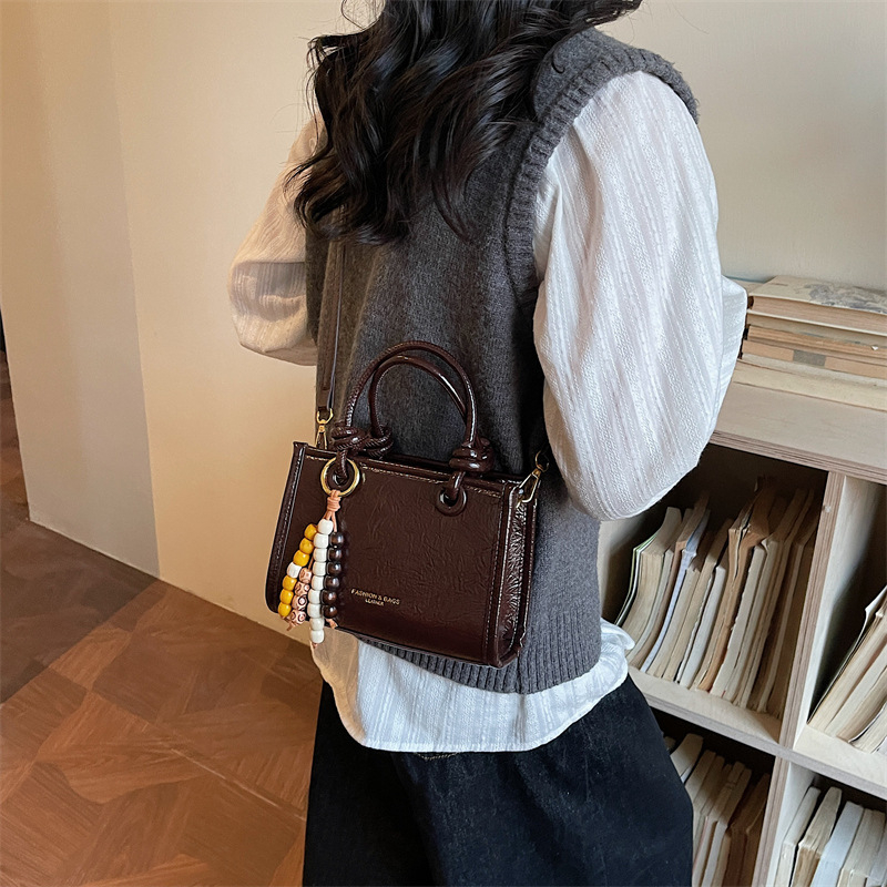 Crossbody torba, gradski minimalistički stil, kvadratni oblik, zatvaranje zatvaračem, proljetna kolekcija 2026