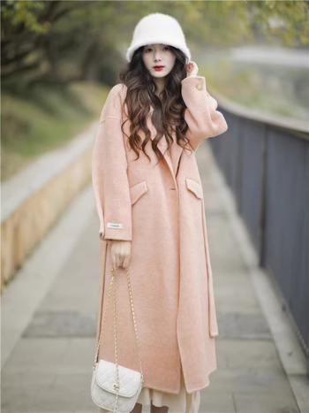 Ženski vuneni kaput, srednje duljine, opuštenog kroja, dvostruko kopčanje, ovratnik stila sakoa, dugi rukavi, ručno šiveno