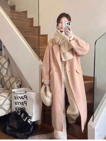 Ženski vuneni kaput, srednje duljine, opuštenog kroja, dvostruko kopčanje, ovratnik stila sakoa, dugi rukavi, ručno šiveno