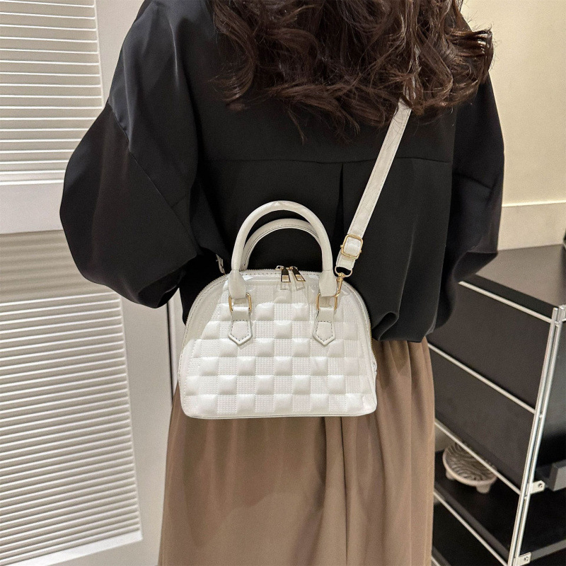 Női kagyló alakú táska műbőrből, keresztpántos, egy vállra hordható, gravírozott rácsmintás, cipzáras zárás, poliészter bélés, dokumentumok zseb, modell HJ9056, Winter 2025 kiadás