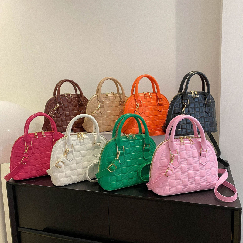 Női kagyló alakú táska műbőrből, keresztpántos, egy vállra hordható, gravírozott rácsmintás, cipzáras zárás, poliészter bélés, dokumentumok zseb, modell HJ9056, Winter 2025 kiadás