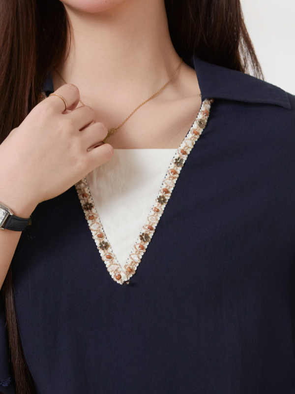 Elegantna ženska bluza s V-izrezom i čipkastim rubom, silueta naglašava pas, dugi rukavi, viskoza