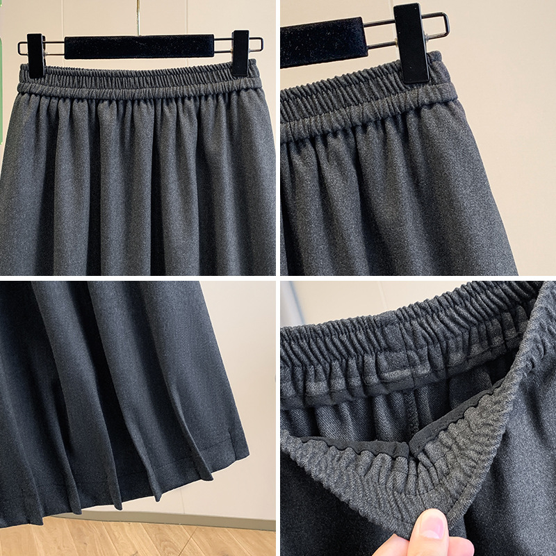 Vunena srednje duga A-linijska suknja s korejskim stilom plisiranog ruba, elastičan pojas i trodimenzionalni kroj; 70–80% pamuka, do 30% elastana.