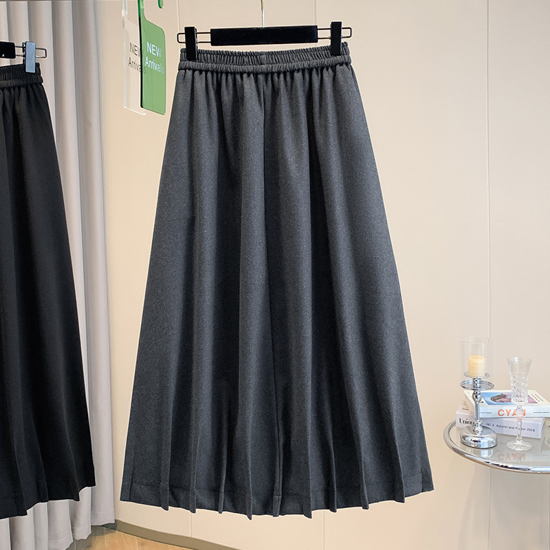 Vunena srednje duga A-linijska suknja s korejskim stilom plisiranog ruba, elastičan pojas i trodimenzionalni kroj; 70–80% pamuka, do 30% elastana.
