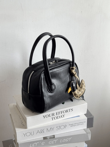 Τσάντα Μπόστον από δέρμα πρώτης στρώσης, με φερμουάρ, θήκη για κινητό και επένδυση από πολυεστέρα.