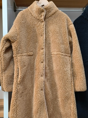 Palton damă, lungime medie, croială lejeră, guler înălțat; fleece din lână de miel artificială; principal poliester 70–80%, cașmir <30%