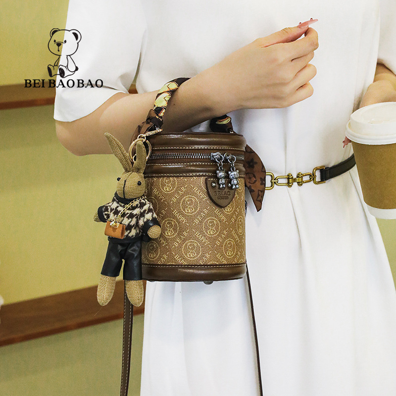 Ženska bucket bag torba, PVC materijal, cilindrični oblik, zatvarač, podstava od platna