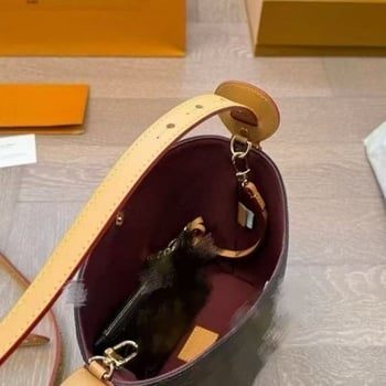 Bucket torba od prave kože, otvorenog vrha, s jednom naramenicom, unutarnja džep za mobitel i laminirani džep sa zatvaračem.