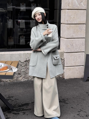 Női visszafordítható gyapjú kabát, középméretű hossz, álló gallér, laza szabás, elülső zárás több gombbal.