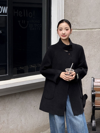 Női visszafordítható gyapjú kabát, középméretű hossz, álló gallér, laza szabás, elülső zárás több gombbal.