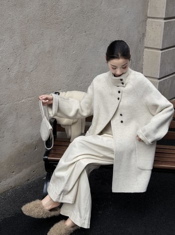 Női visszafordítható gyapjú kabát, középméretű hossz, álló gallér, laza szabás, elülső zárás több gombbal.