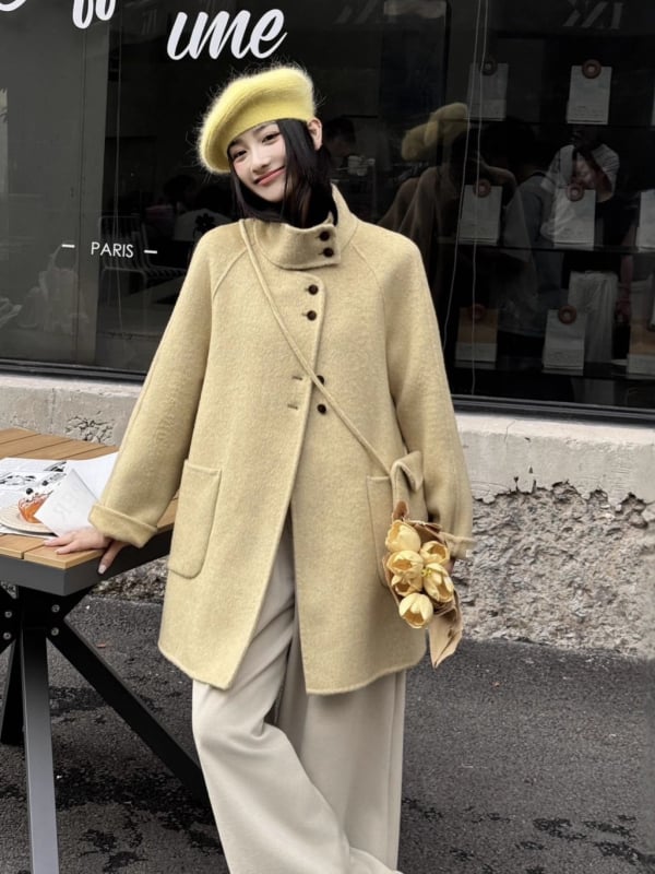 Női visszafordítható gyapjú kabát, középméretű hossz, álló gallér, laza szabás, elülső zárás több gombbal.