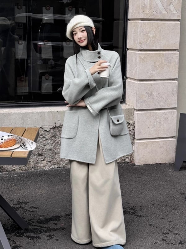 Női visszafordítható gyapjú kabát, középméretű hossz, álló gallér, laza szabás, elülső zárás több gombbal.