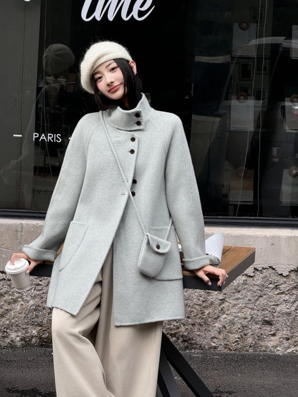 Női visszafordítható gyapjú kabát, középméretű hossz, álló gallér, laza szabás, elülső zárás több gombbal.