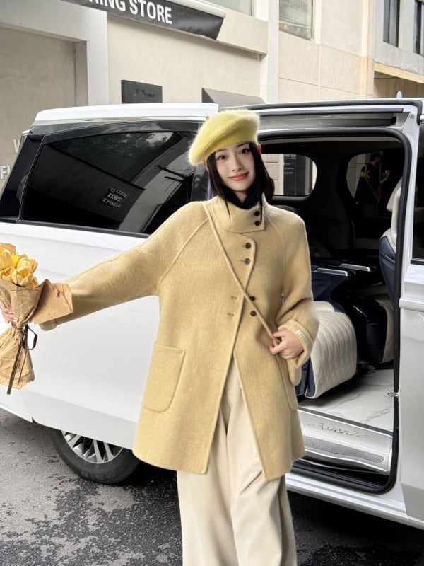 Női visszafordítható gyapjú kabát, középméretű hossz, álló gallér, laza szabás, elülső zárás több gombbal.