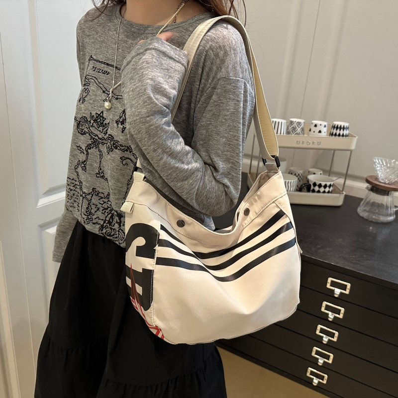 Ženska crossbody torbica od Oxford platna s motivom slova, lagana, horizontalno kvadratnog oblika, zatvaranje na zip, laminirani unutarnji džep
